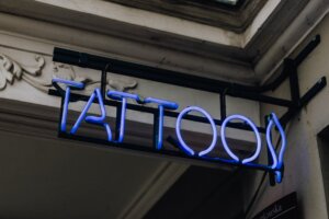 Blaues Neon Schild mit der Aufschrift Tattoo